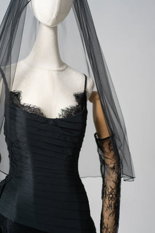 An exquisite black corset set with tulle texture and a luxurious train that creates a dramatic and architectural silhouette