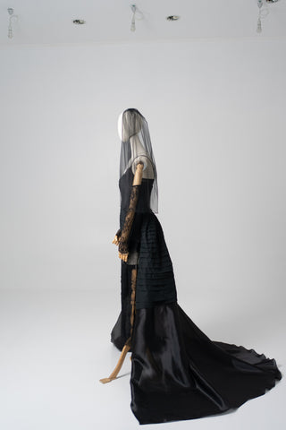 An exquisite black corset set with tulle texture and a luxurious train that creates a dramatic and architectural silhouette