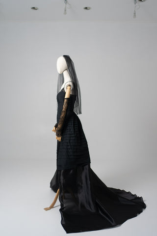 An exquisite black corset set with tulle texture and a luxurious train that creates a dramatic and architectural silhouette