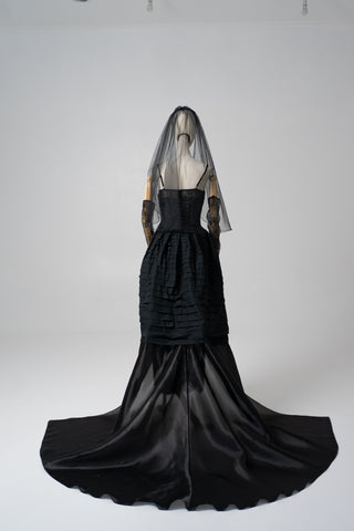 An exquisite black corset set with tulle texture and a luxurious train that creates a dramatic and architectural silhouette