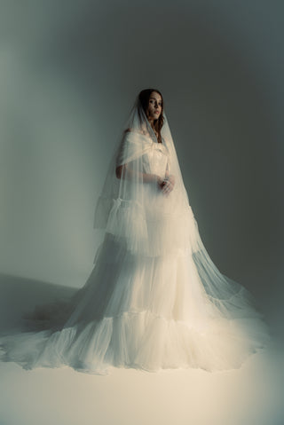 A long veil with a lush multi-level gathering that creates a voluminous silhouette and an effect of fairy-tale lightness