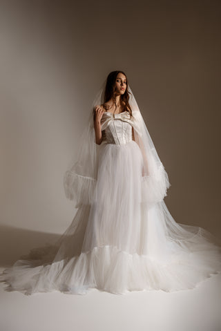 A long veil with a lush multi-level gathering that creates a voluminous silhouette and an effect of fairy-tale lightness