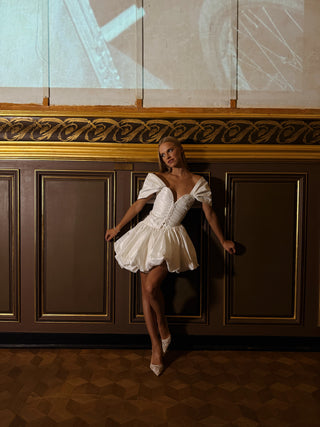 Short dress with a fluffy skirt on a corset — a model with dropped sleeves and a corset base