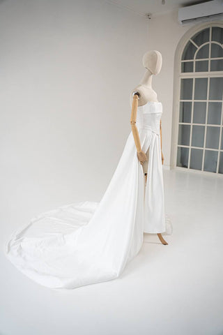 Wedding dress-transformer with a deep cut and a semi-circular long train