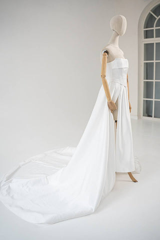 Wedding dress-transformer with a deep cut and a semi-circular long train